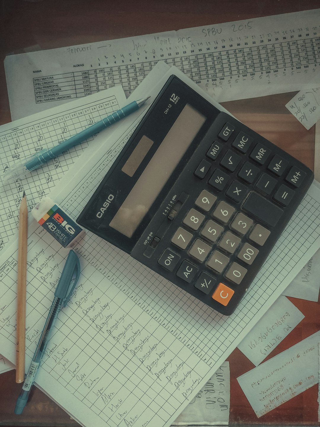Calculator sitting on a pile of financial papers